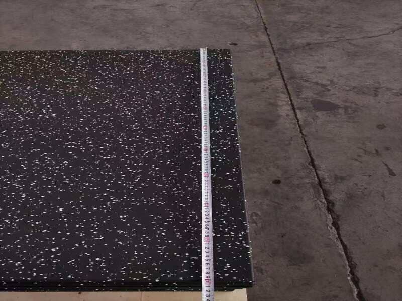 Hand performing scratch test on rubber floor with visible residue